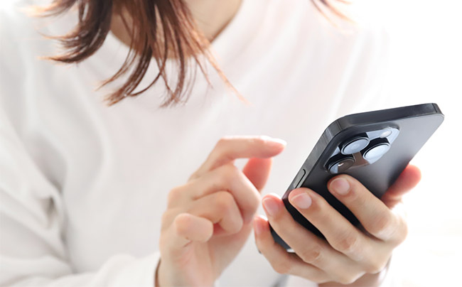 スマートフォンで電話をかけようとしている女性