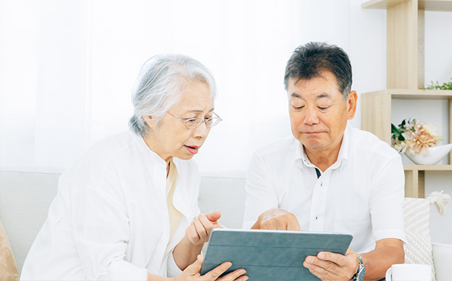 タブレットを見ながら悩んでいる夫婦