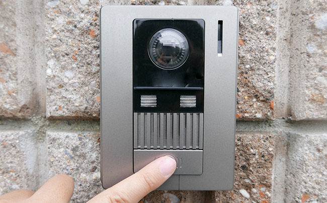 インターホンを押そうとしている指