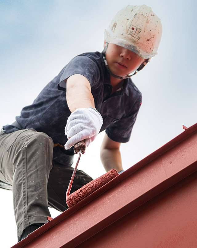 屋根塗装をしている職人