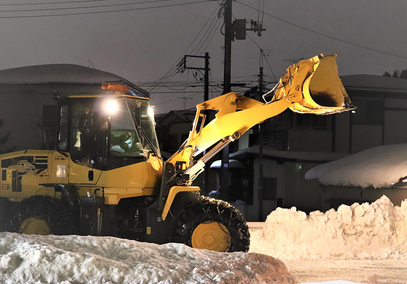 深夜に除雪している除雪機